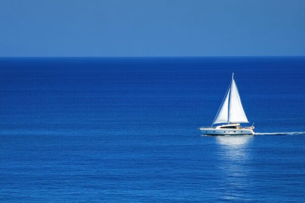 A majestic yacht, with pristine white sails, gliding effortlessly across the calm ocean.